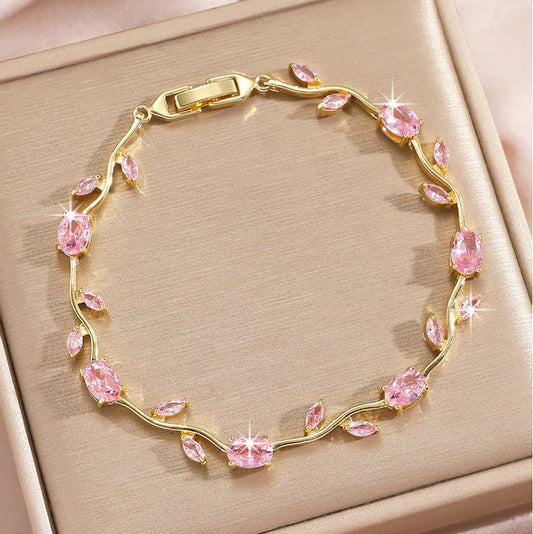 Gold bracelet with pink gemstones on a beige background