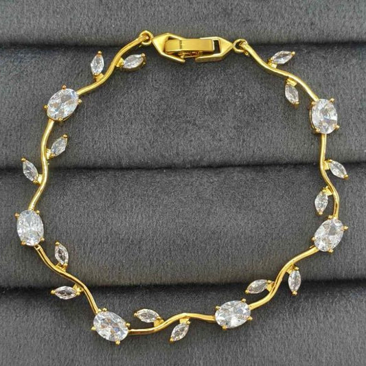 Gold bracelet with clear stones on a gray surface