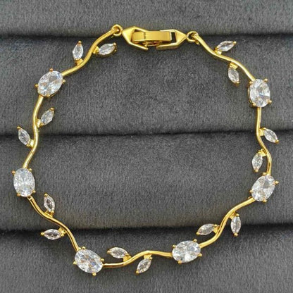 Gold bracelet with clear stones on a gray surface