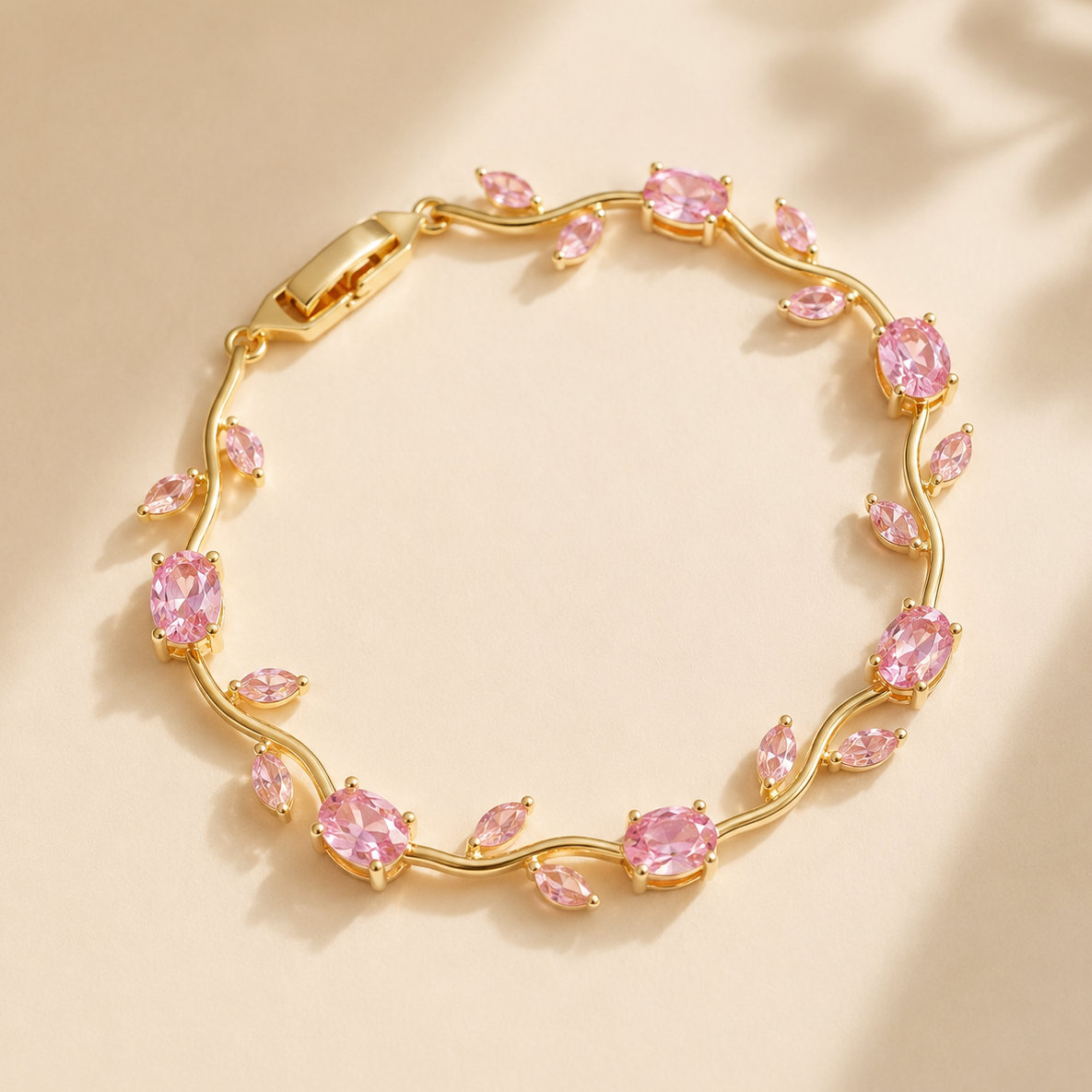 Gold bracelet with pink gemstones on a beige background