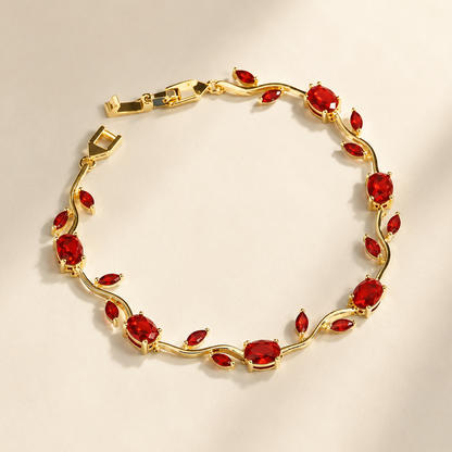Gold bracelet with red gemstones on a beige background