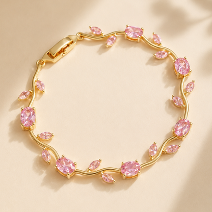 Gold bracelet with pink gemstones on a beige background